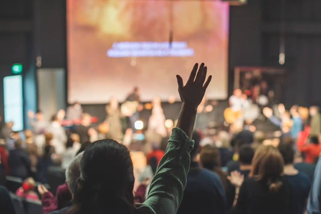 Hands in the air of people who praise God at church service